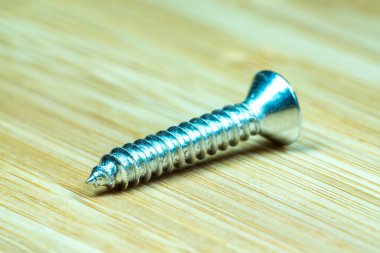 Bambu doku yüzeyi arka planında somunlar ve cıvatalar yakın çekim