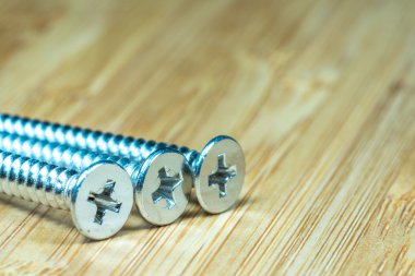 Bambu doku yüzeyi arka planında somunlar ve cıvatalar yakın çekim