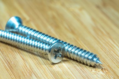 Bambu doku yüzeyi arka planında somunlar ve cıvatalar yakın çekim