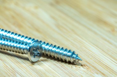 Bambu doku yüzeyi arka planında somunlar ve cıvatalar yakın çekim