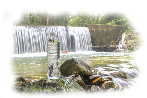 Drinking bottle at waterfall — Stock Photo, Image