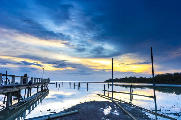 青い時間ビューで夕日の背景を持つ桟橋のシルエット — ストック写真