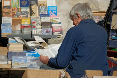 Lviv, Ukrayna - 4 Ekim 2014: Kitap bit pazarı anıt Ivan Fyodorov yakın. Yaşlı adam ikinci el kitap yakınındaki diğer kayıtlarda 4 Ekim 2014, Lviv, Ukrayna üzerinden seyir.