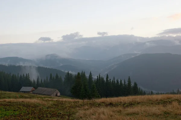 View of mountain houses on the hill in Carpathians in the evening with air perspective