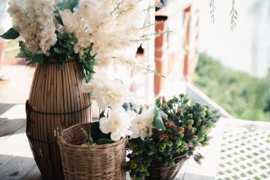 İçinde beyaz çiçekler olan saksılar kahve dükkanındaki masanın üzerine konur..