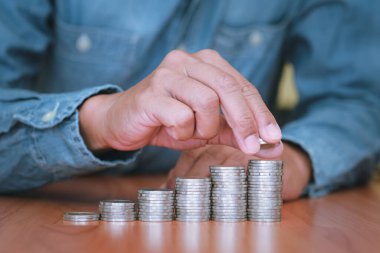 Yakından bakınca iş adamı bozuk para biriktiriyor. Gelecek için tasarruf ve yatırım kavramı.