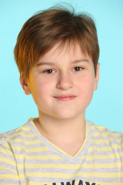 Açık çizgili tişörtlü, modaya uygun ve çekici bir genç, yakın plan bir portrede hafifçe gülümsüyor..