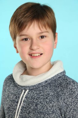 Yakın plan portre: yakışıklı, zeki, sorumluluk sahibi ve göz göze gelen genç bir çocuk..