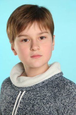 Yakın plan portre: yakışıklı, zeki genç çocuk ciddi ve dikkatli bir şekilde göz göze gelir..