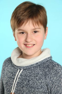 Yakın plan portre: yakışıklı, yetenekli genç çocuk geniş bir gülümsemeyle göz göze gelir..