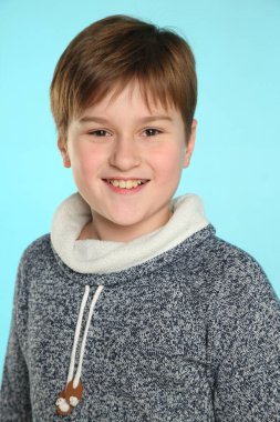 Yakın plan portre: yakışıklı, yetenekli genç çocuk geniş bir gülümsemeyle göz göze gelir..