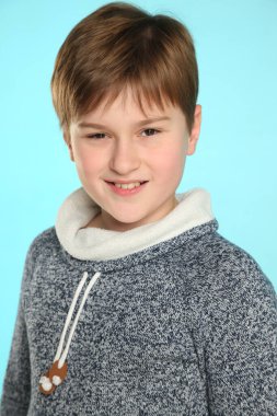 Yakın plan portre: yakışıklı, yetenekli genç bir çocuk sinsi bir bakışla gülümsüyor ve göz göze geliyor..