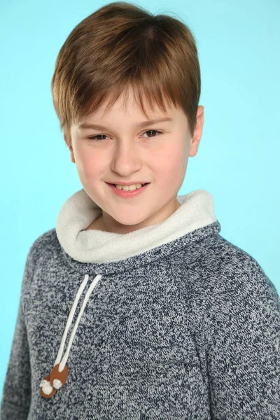 Yakın plan portre: yakışıklı, yetenekli genç bir çocuk sinsi bir bakışla gülümsüyor ve göz göze geliyor..