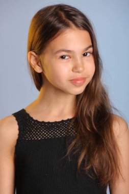 Siyahlar içindeki parlak siyah saçlı genç kızın yakın plan portresi, tatlı tatlı gülümsüyor ve göz göze geliyor..