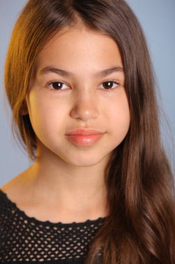 Siyahlar içindeki parlak siyah saçlı genç kızın yakın plan portresi, tatlı tatlı gülümsüyor ve göz göze geliyor..