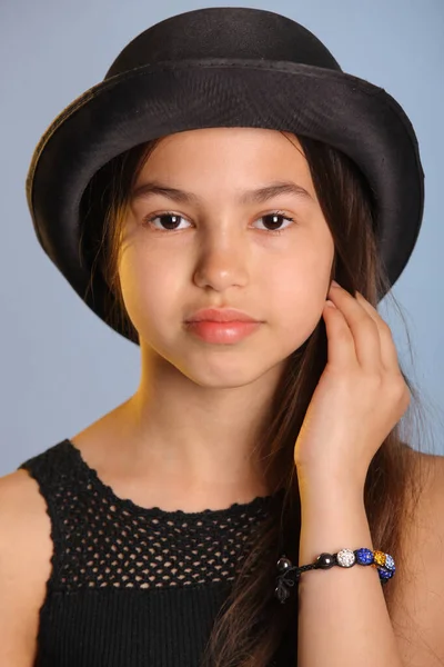 12岁的小女孩戴着一顶黑色圆顶礼帽 有着一头明亮而可爱的黑发 她的近照 与她的棕色眼睛对视着 — 图库照片