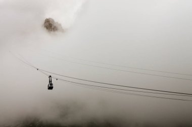 Bulutların arasından dağlara giden teleferik.