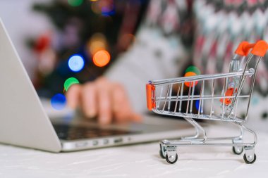 Noel alışverişi. Kadın hediyeler alır, Noel 'e hazırlanır, alışveriş arabaları ve hediye kutuları arasında. Kış tatili Mutlu Noeller kış tatili satış konsepti. Seçici odak