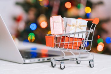 Noel alışverişi. Kadın hediyeler alır, Noel 'e hazırlanır, alışveriş arabaları ve hediye kutuları arasında. Kış tatili Mutlu Noeller kış tatili satış konsepti. Seçici odak