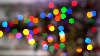 Yılbaşı ağacının bulanık silueti ve odağında parlayan ışıklar. Dikey 4k video. İç kısımda noel ağacı ve sönmüş ışıklar. Noel 'in bulanık geçmişi. Xmas ağacından ışık bokeh. 