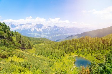 Avrupa 'nın Alplerinde dağlarda gölü olan büyülü cennet manzarası. Alplerdeki yeşil tepelerde turist gezisi. Güzel kaya ve dağ zirvelerinin muhteşem manzarasına hayranım. Dağ gölünde güneşli harika bir gün.