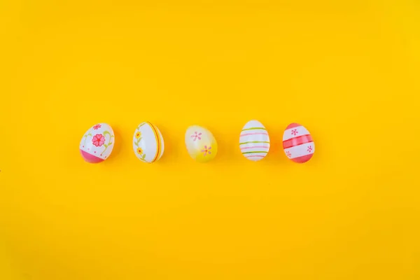 Kolorowe Wielkanoc malowane tło jaj na żółtym pastelowym tle koloru z przestrzeni. Święta Wielkanocne. Tradycyjna dekoracja na wiosenne wakacje. Widok z góry Wielkanoc kartka okolicznościowa — Zdjęcie stockowe