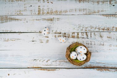 Paskalya bayramı beyaz ahşap masada lalelerle benekli yumurtaları sepete boyamıştı. Geleneksel bahar kompozisyonu ilkbahar için Paskalya elementleri çiçekler ve yumurtalar. Bahar dekorasyonu konsepti.