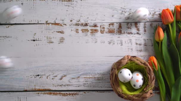 Видео Многоцветные Пасхальные Яйца Катятся Белому Деревянному Столу Тюльпанами Традиционная — стоковое видео
