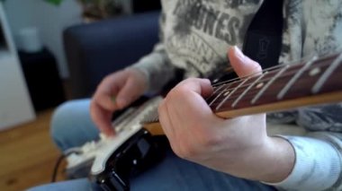 Gitar çalan müzisyen. Elektro gitarda çalan bir müzik sanatçısı. Arabulucuyu tutan, melodi yapan, nota ve akor çalan, gitarda çalan parmaklar. Gitarist okulu. Gitar görünümünü kapat.