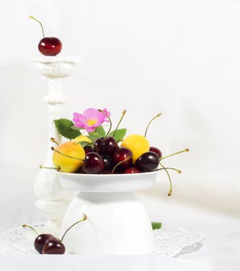 Olgun tatlı kiraz ve kayısı için meyve seçici odak çizmek, etkileri, beyaz bir vazo içinde tonlama