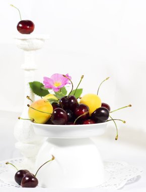 Olgun tatlı kiraz ve kayısı için meyve seçici odak çizmek, etkileri, beyaz bir vazo içinde tonlama