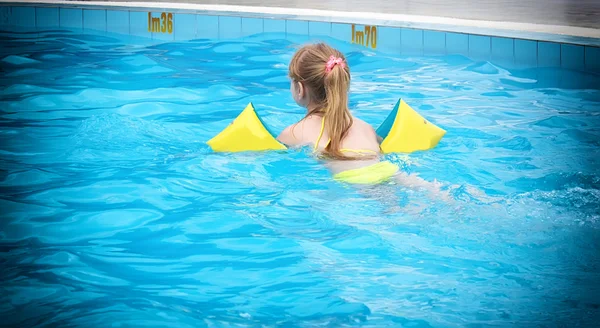 Dziewczyna dowiaduje się, pływać w basenie — Zdjęcie stockowe