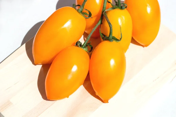 Cluster de tomate amarelo na textura leve de madeira — Fotografia de Stock