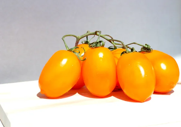 Grappolo di pomodoro giallo su texture leggera in legno — Foto Stock