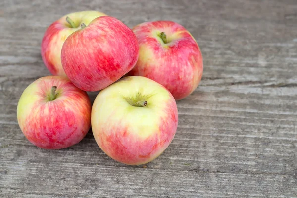 Small group of fresh natural apples on wooden texture — Stock Photo, Image