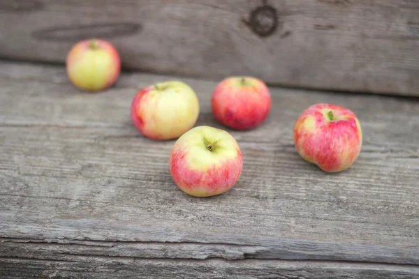 Small group of fresh natural apples on wooden texture — Stock Photo, Image
