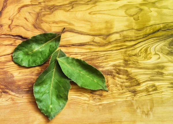 stock image Green bay leaf on wooden texture