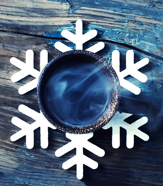 Cup with hot coffee on the on support in the form of a snowflake — Stock Photo, Image