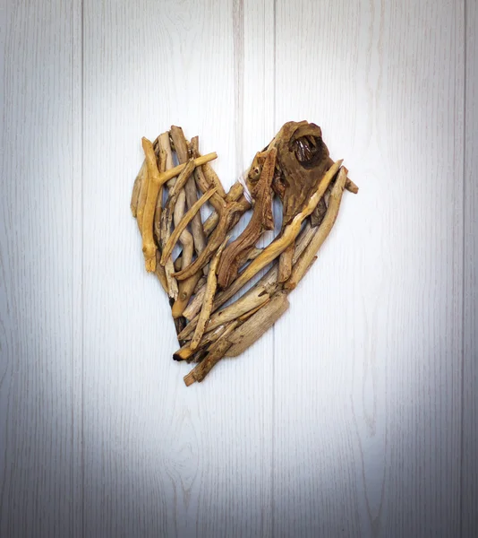 Das hölzerne Herz aus natürlichen Haken, das an der Wand hängt — Stockfoto