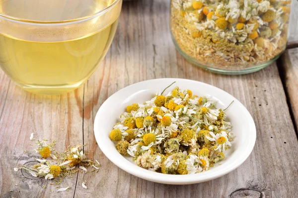 Dried camomile flowers on saucer. — Stock Photo, Image