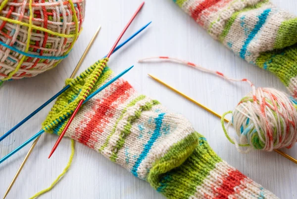 Görünür yün iplik ve iğnelerle örülmüş bir çorabı kapat, detaylı doku ve dikişleri göster, geleneksel örgü ve el işi tekniklerini göstermek için mükemmel.