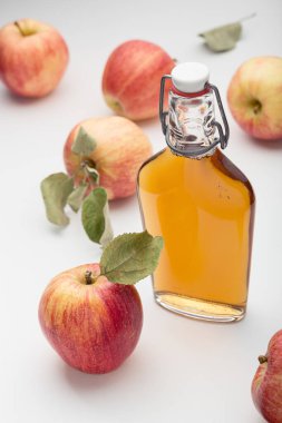 Taze elmalar ve elma sirkesi. Cam şişede elma şarabı ve taze elmalar. Hafif arkaplan. 