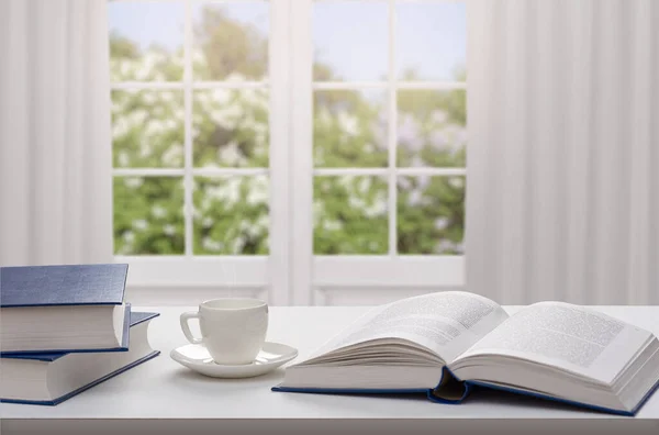 Kitap ve kahve yığını ahşap masanın üzerinde. Hafif arkaplan.