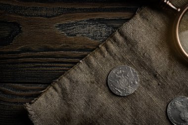 Numismatikler. Masanın üzerinde eski koleksiyonluk gümüş paralar var. Üst görünüm.