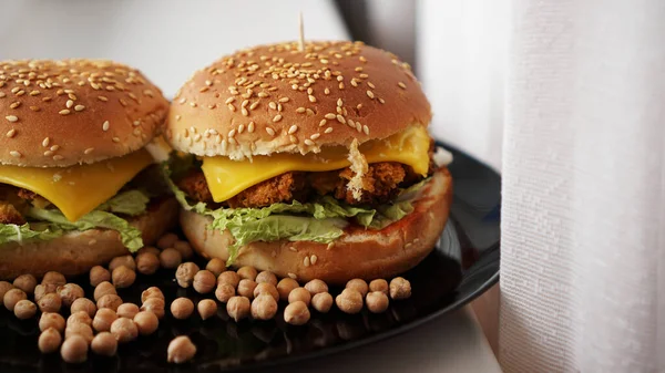 Hamburguesa vegetal con chuleta de garbanzo. Dos hamburguesas en plato negro —  Fotos de Stock