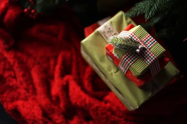 Schöne weihnachtsgrüne Geschenkboxen unter dem Weihnachtsbaum auf roter Decke — Stockfoto