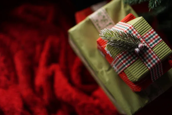 Schöne weihnachtsgrüne Geschenkboxen unter dem Weihnachtsbaum auf roter Decke — Stockfoto