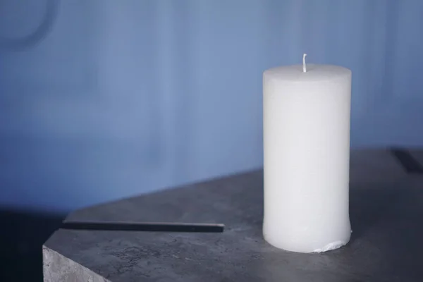 Big white candle on blue background — Stock Photo, Image