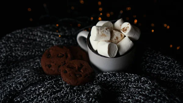 Tazza con marshmallow e biscotti con gocce di cioccolato su sfondo di Natale scuro — Foto Stock
