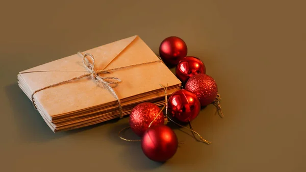 Composição de Natal. Envelopes de artesanato e bolas vermelhas. Pilha de letras — Fotografia de Stock